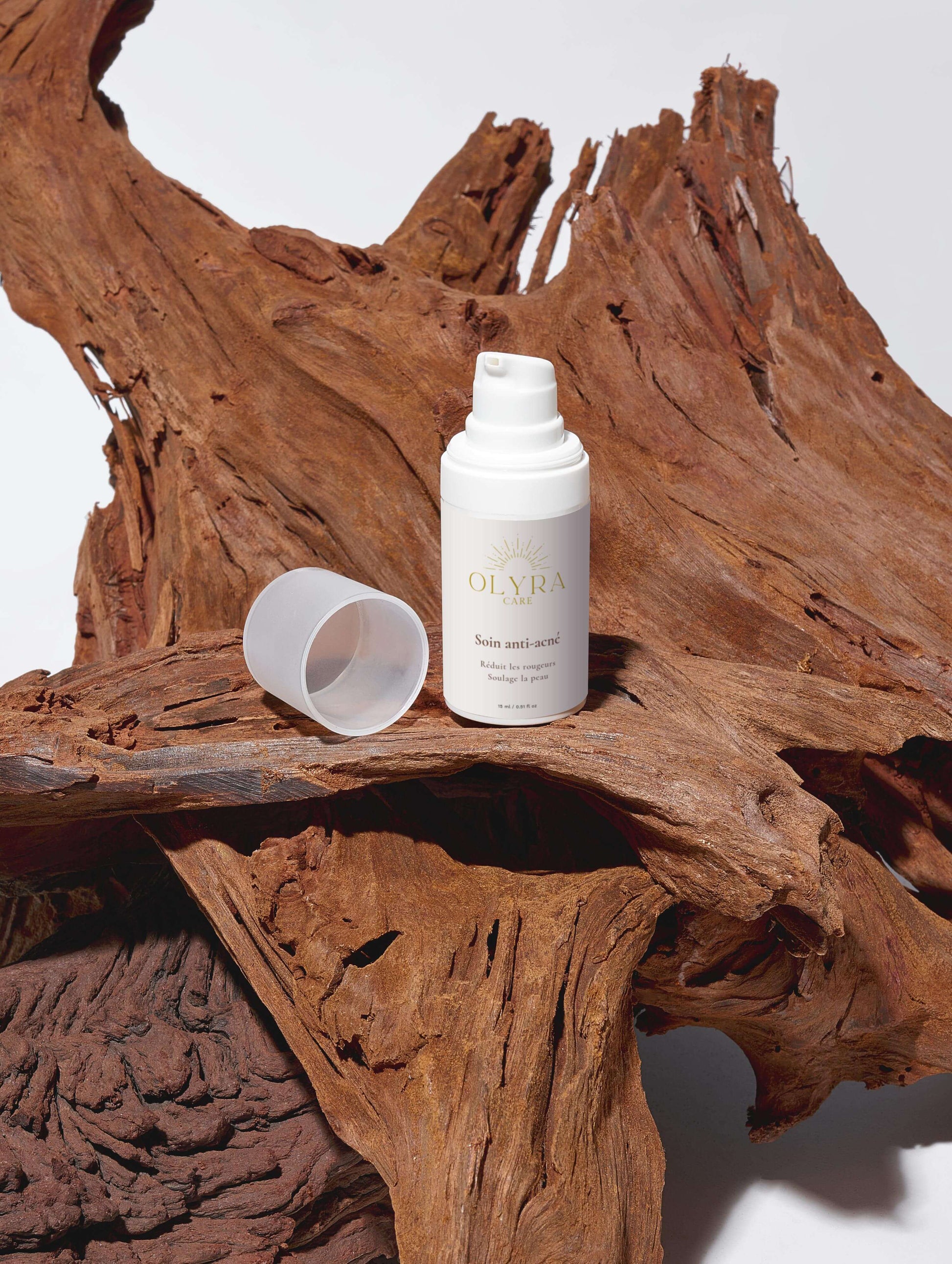 Soin Anti-Acné Olyra Care sur une surface en bois, flacon avec bouchon ouvert pour un effet purifiant.